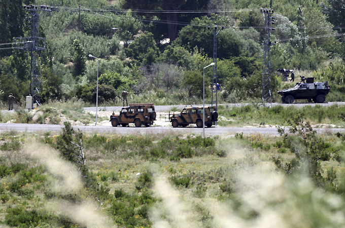 Turkish soldiers wait at the border zone between Syria and Turkey, near the Turkish village of Guvecci, 50 kilometres (31 miles) from Hatay province June 11, 2011. Terrified Syrians continued to stream into Turkey on Friday, crowding into refugee camps already teeming with mostly women and children. REUTERS/Osman Orsal (TURKEY - Tags: CIVIL UNREST MILITARY SOCIETY POLITICS CONFLICT)