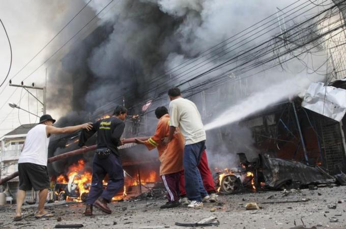 Security forces and firefighters work at the scene of a car bomb attack in southern Thailand''s Narathiwat province