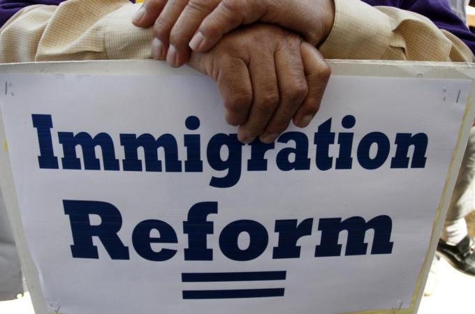 A man holds a protest sign during a rally for immigration reform in Los Angeles, California