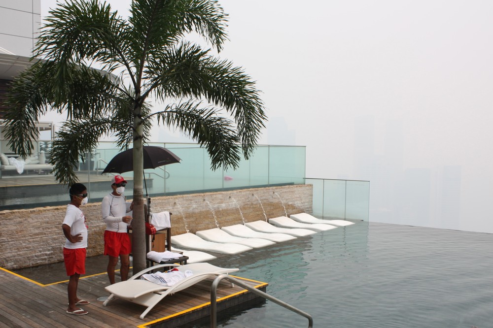 <p>Two lifeguards wear masks at a swimming pool on the top floor of the Marina Bay Sands Hotel as haze hits Singapore. </p>