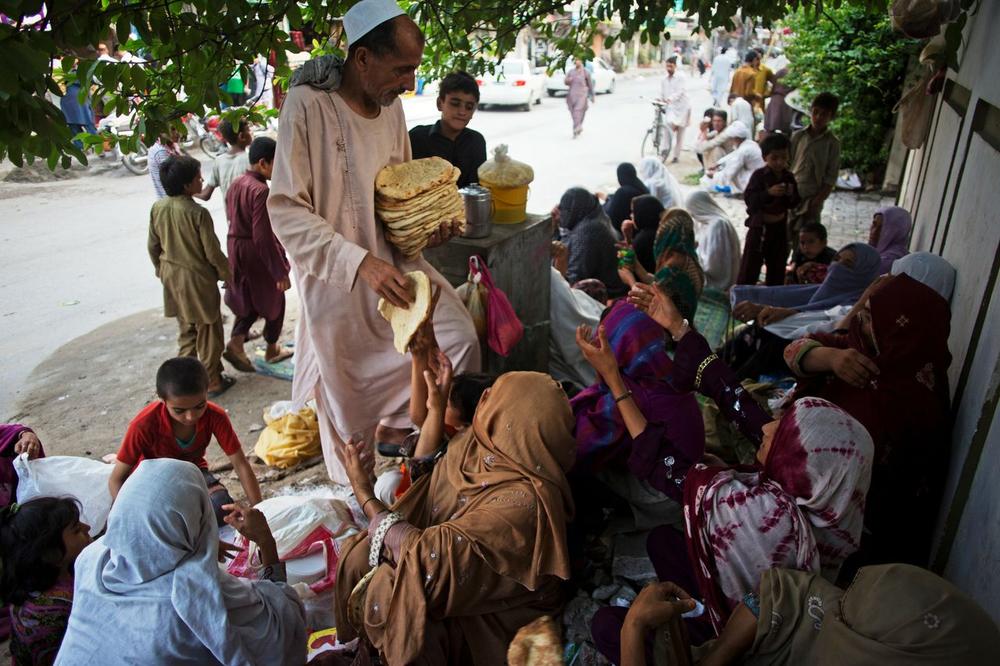 <p><span style="font-family: arial, helvetica, sans-serif;">The owner of a bakery in Islamabad, Pakistan hands out bread to Pashtun Afghan refugee families before iftar.</span></p>