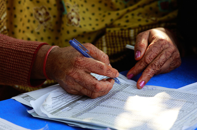 A health worker fills out a log of homes that have been covered in the Polio immunization campaign in a neighborhood of Karachi, Pakistan [Max Becherer]