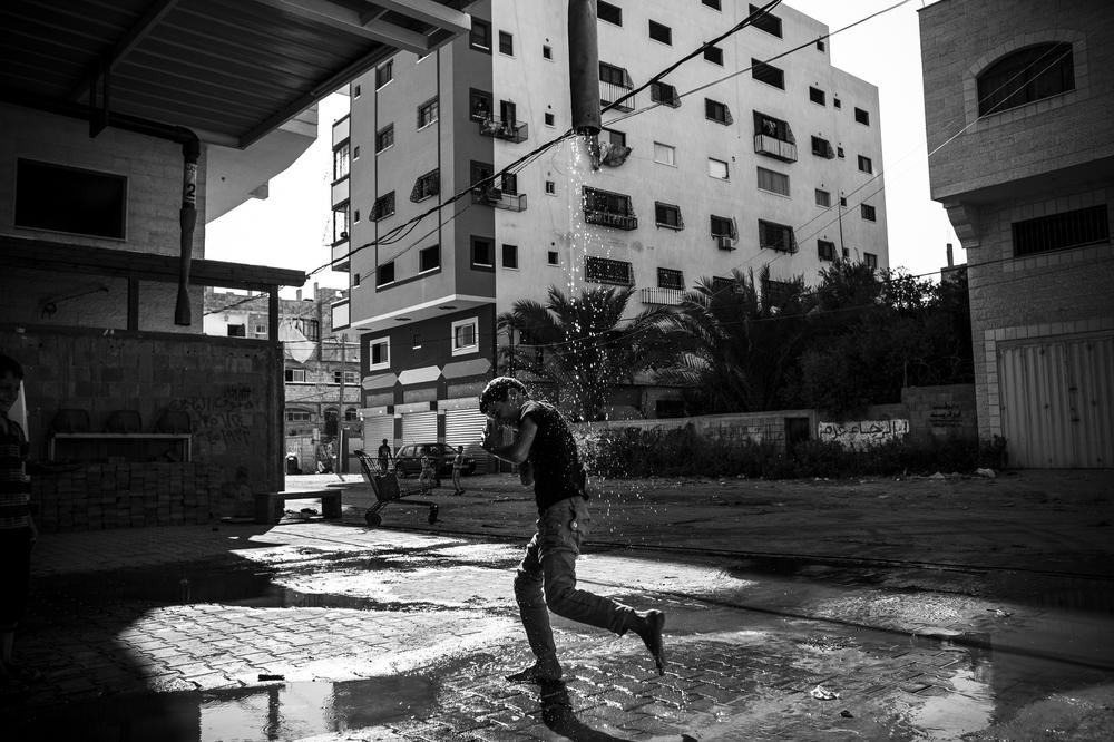 <p>A boy plays at a water pump in central Gaza City.</p>