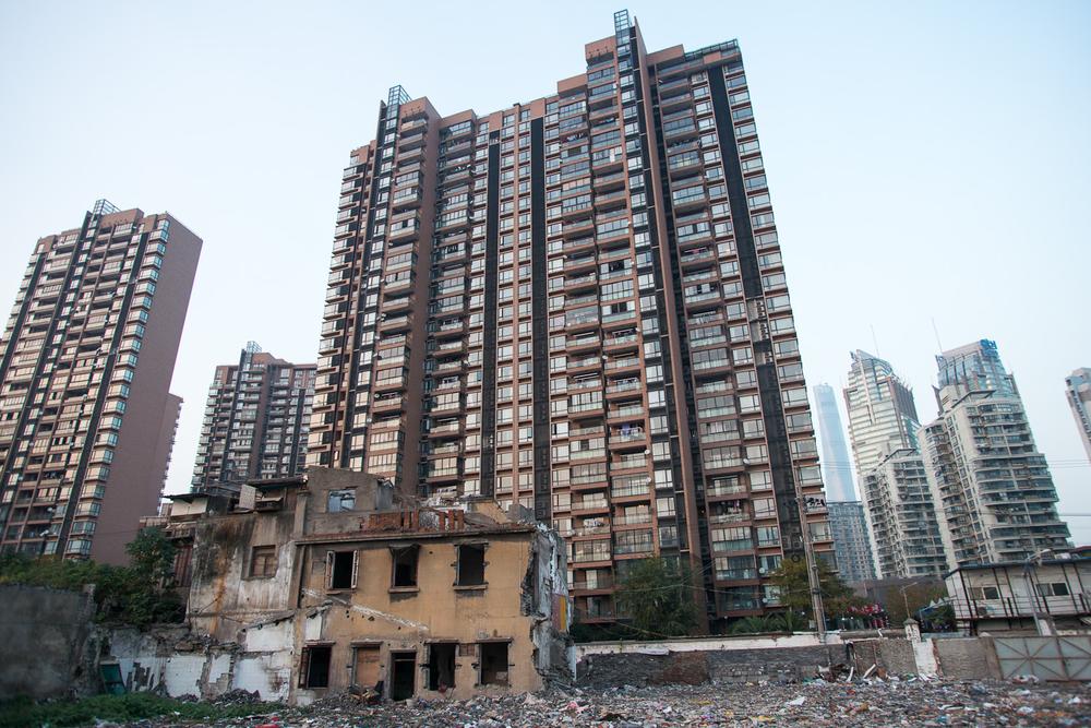 <p>A section of a colonial-era building stands on the edge of an old residential block that has been cleared to make way for more high-rise development, such as those seen in the background. </p>