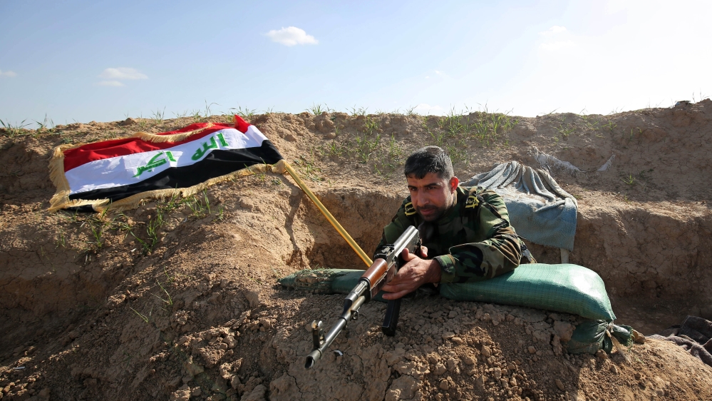 A Shia militia fighter aims his weapon on the frontline just outside the city of Kirkuk [AP]