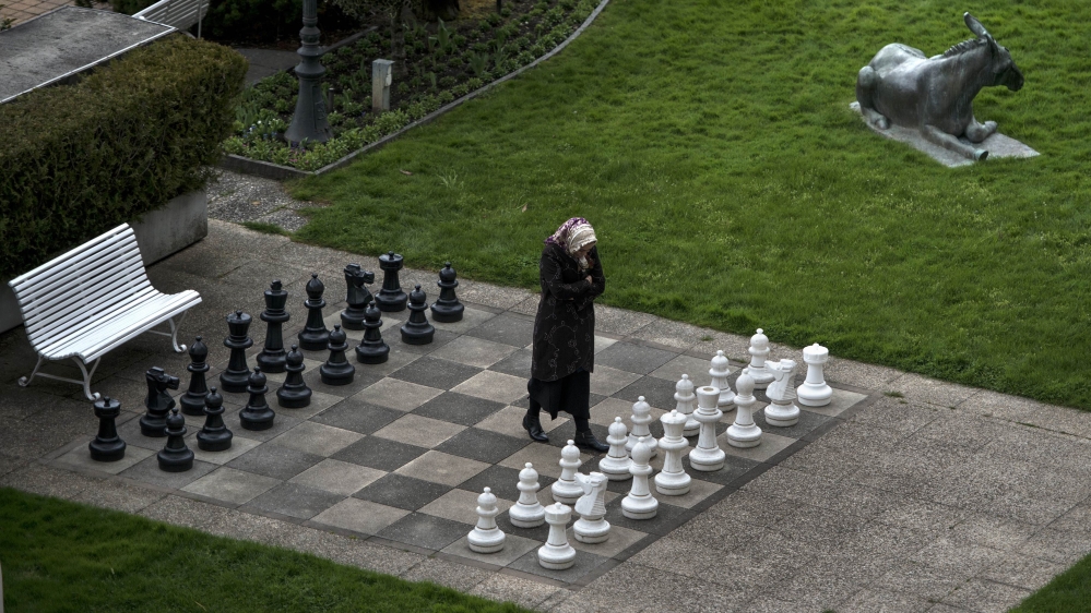 A member of the Iranian media walks on an open air chess board at the site of negotiations about Iran''s nuclear program in Lausanne, Switzerland [AP]