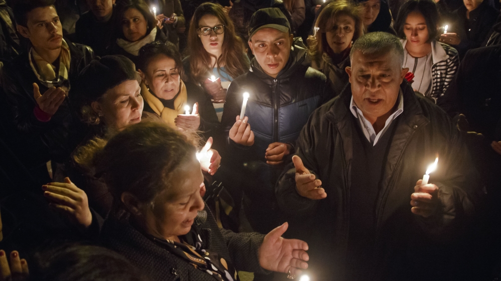 Tunisians holding candles pray at the entrance gate of the National Bardo Museum where scores of people were killed after gunmen staged an attack, Tunis [AP]