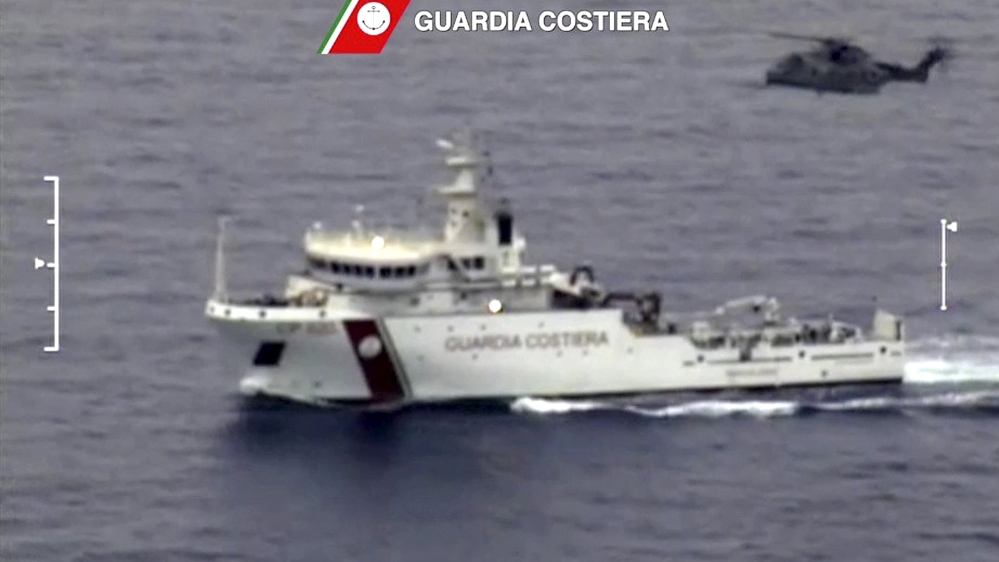 An Italian coast guard vessel and helicopter in migrants search