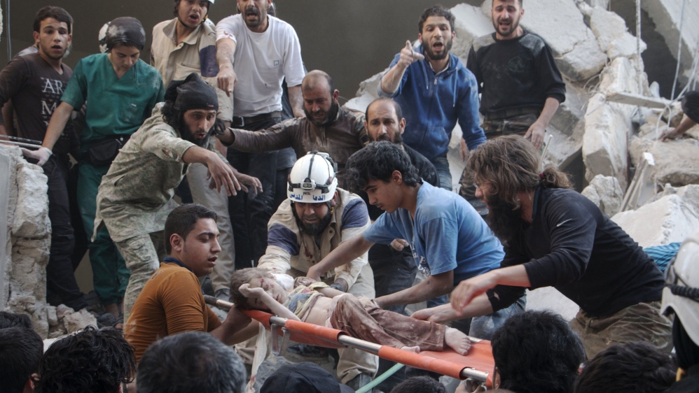Syrian rescue workers and citizens carry a child on a stretcher from a building following a reported barrel bomb attack by Syrian government forces in Aleppo [AFP]