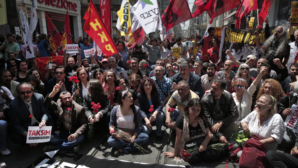 Holding carnations, banners and pictures of the people that lost their lives in the Gezi Park protests in Istanbul [AP]