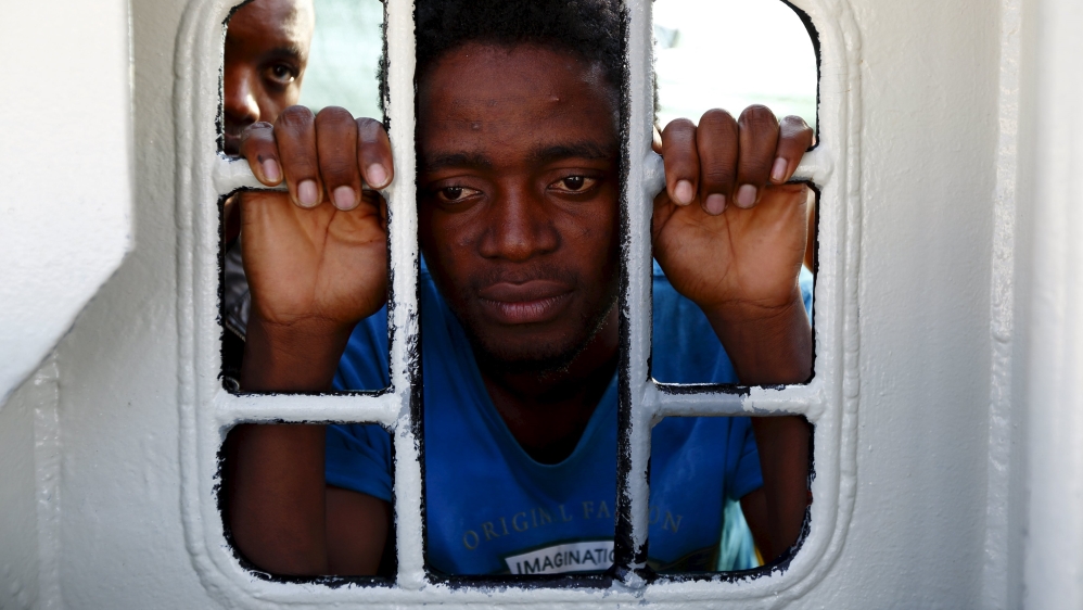Migrants look out of a window on the Medecins Sans Frontiere (MSF) rescue ship Bourbon Argos as it arrives in Trapani, on the island of Sicily