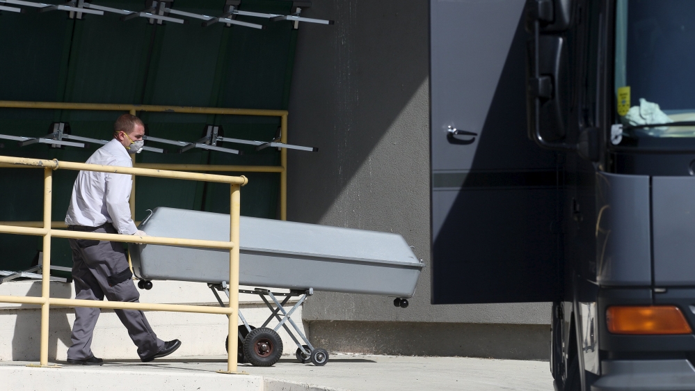 A coffin is rolled onto a truck at a customs building with refrigeration facilities in the village of Nickelsdorf