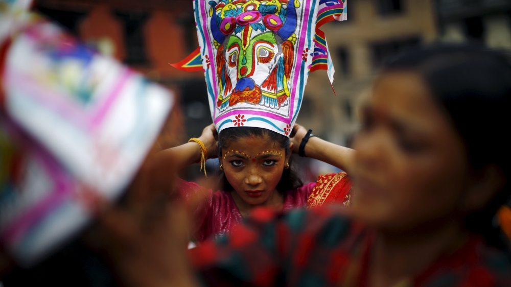 A girl depicting a holy cow gets ready to take part in a parade to mark the Gaijatra Festival, also known as the festival of cows, in Kathmandu