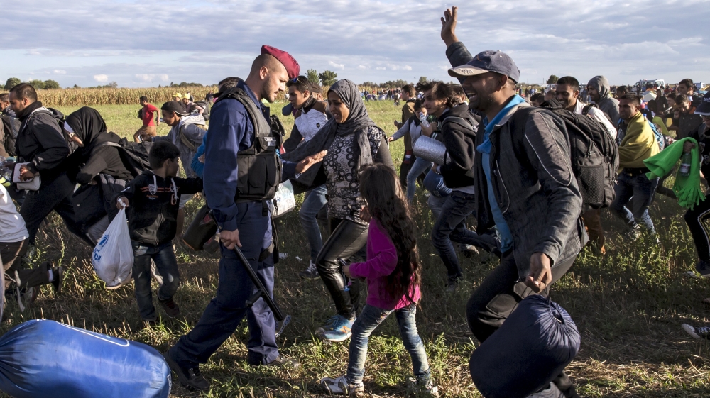 Group of migrants leaves a collection point in the village of Roszke