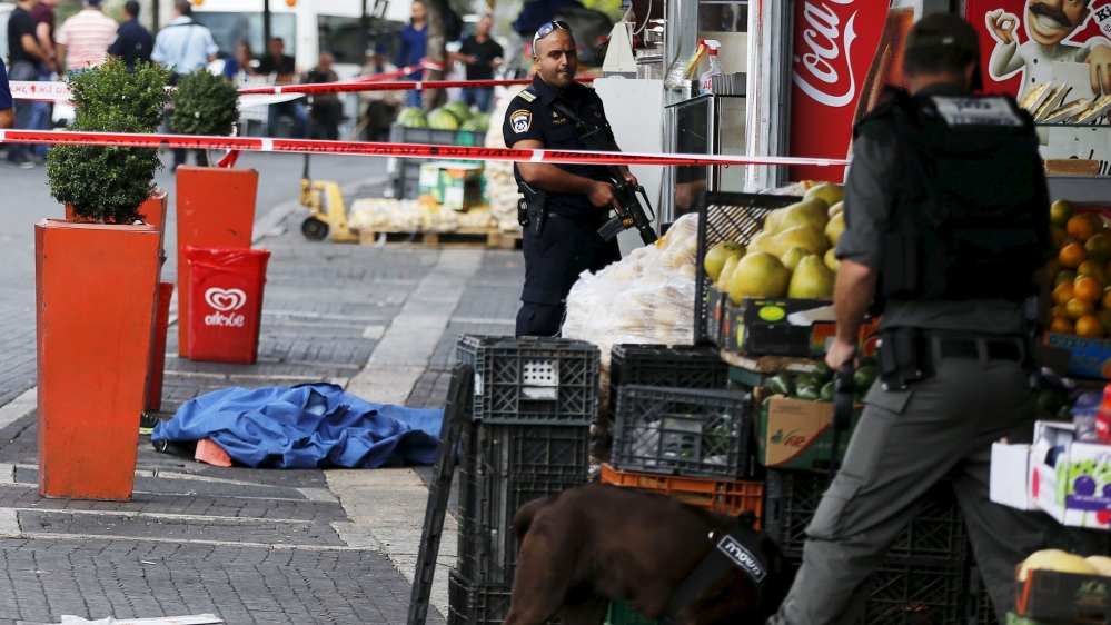 Israeli police stand next to the body of a dead Palestinian assailant at the spot where he stabbed two Israeli Jews before he was shot dead outside Jerusalem''s Old City