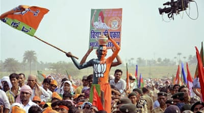 A supporter of BJP waves the party flag during an election campaign rally addressed by Modi in Bihar [Reuters]