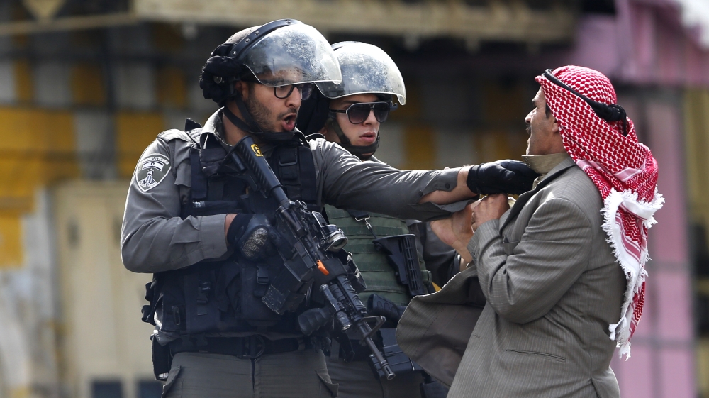 A Palestinian is pushed an Israeli policemen amid clashes in Hebron,