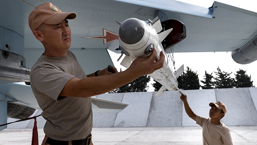 Russia''s Defence Ministry handout photo shows Russian ground staff members loading a Sukhoi Su-30 fighter jet with weapons at the Hmeymim air base near Latakia, Syria