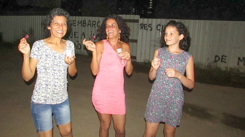 Dona Penha, Sandra and Pérola Luz at a community event [Maya Thomas-Davis/Al Jazeera]