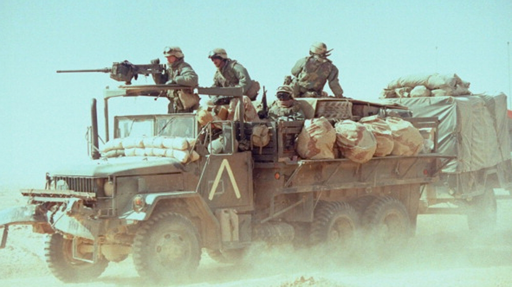During the first Gulf War, US soldiers keep watch and man their weapons on a truck that tows an equipment trailer, Saudi Arabia (1991) [Getty]