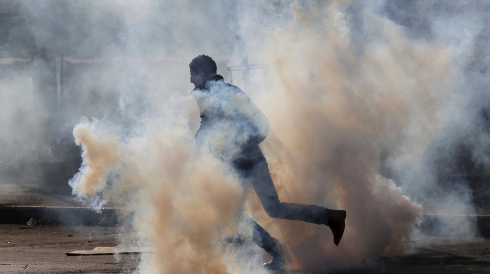 A Palestinian protester runs for cover from tear gas fired by Israeli troops during clashes in the West Bank city of Bethlehem [REUTERS]