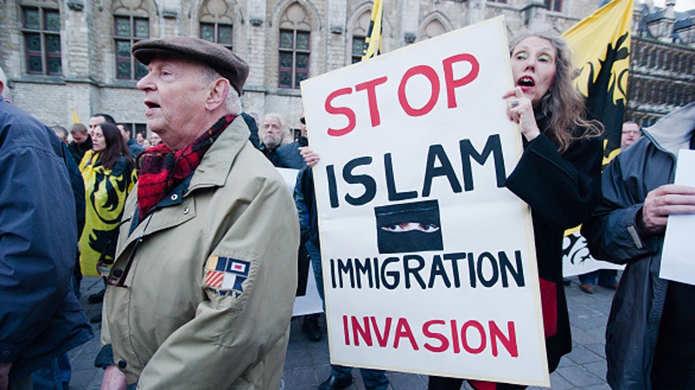 A member of PEGIDA Flanders holds an anti-Islam sign in Ghent, Belgium [Getty]