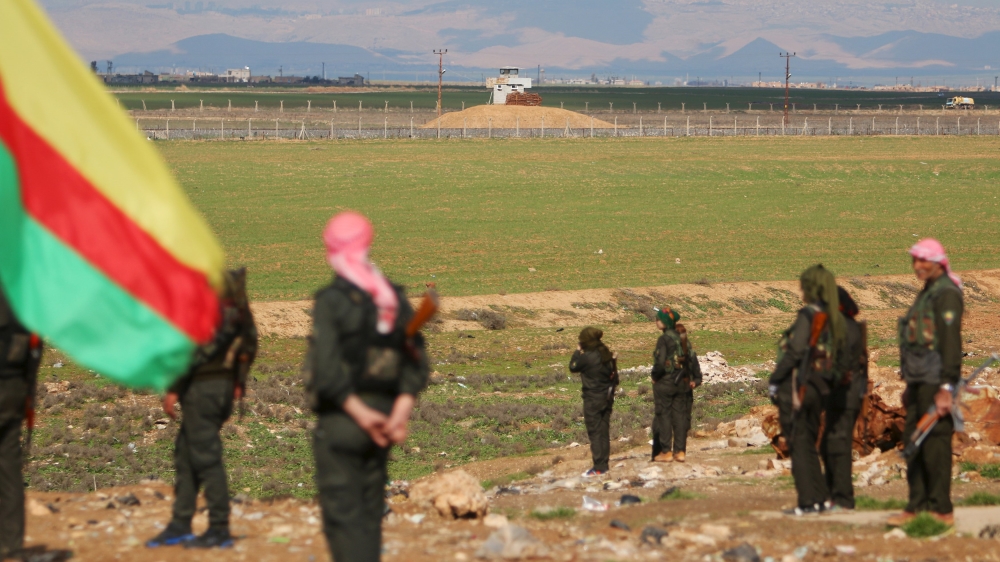 Kurdish fighters stand near the Syrian-Turkish border during a protest against Turkish operations against the Kurds [REUTERS]