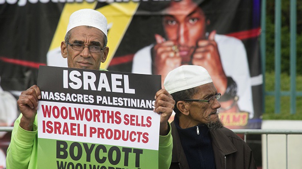 A South African man holds a placard during a protest in Cape Town [AFP]