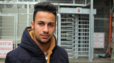 Ahmad Azzah, pictured by the Tel Rumeida checkpoint, says Palestinians in the area 'live like prisoners' [Abed al Qaisi/Al Jazeera]