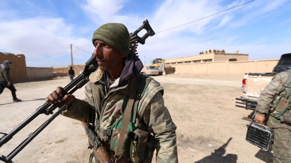 Syria Democratic Forces fighters carry their weapons in a village on the outskirts of al-Shadadi town, Hasaka countryside, Syria [REUTERS]