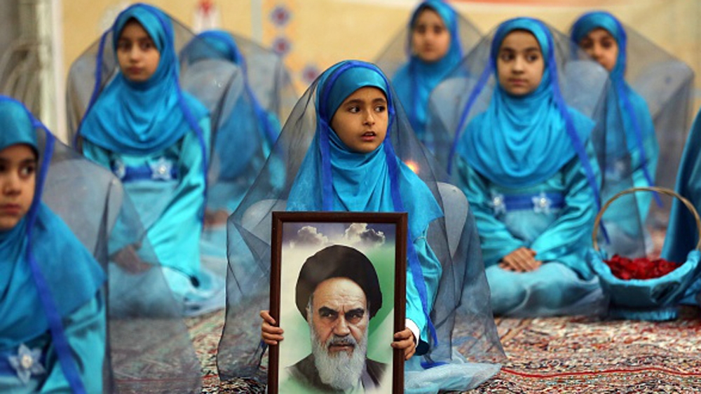A young Iranian girl holds a portrait of the founder of Iran''s Islamic Republic, Ayatollah Ruhollah Khomeini [AFP]