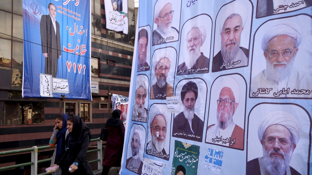 File photo of women walking past electoral posters for the upcoming elections in central Tehran
