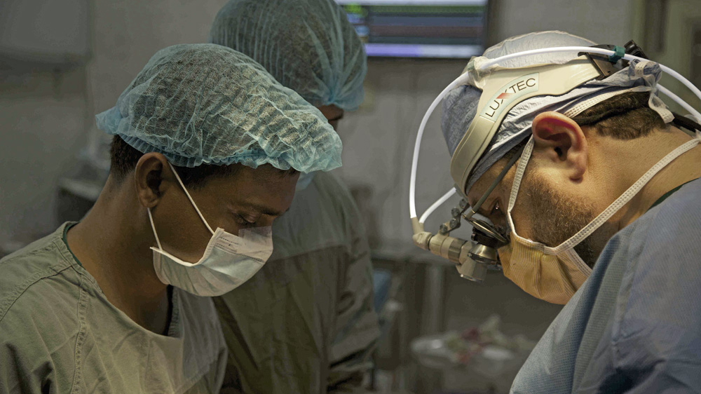 Saudi surgeon Mohammad Shihata, right, performs open-heart surgery with Bangladeshi colleague Abdul Hannan, left, who says assisting is the best training [Hannah McNeish/Al Jazeera]