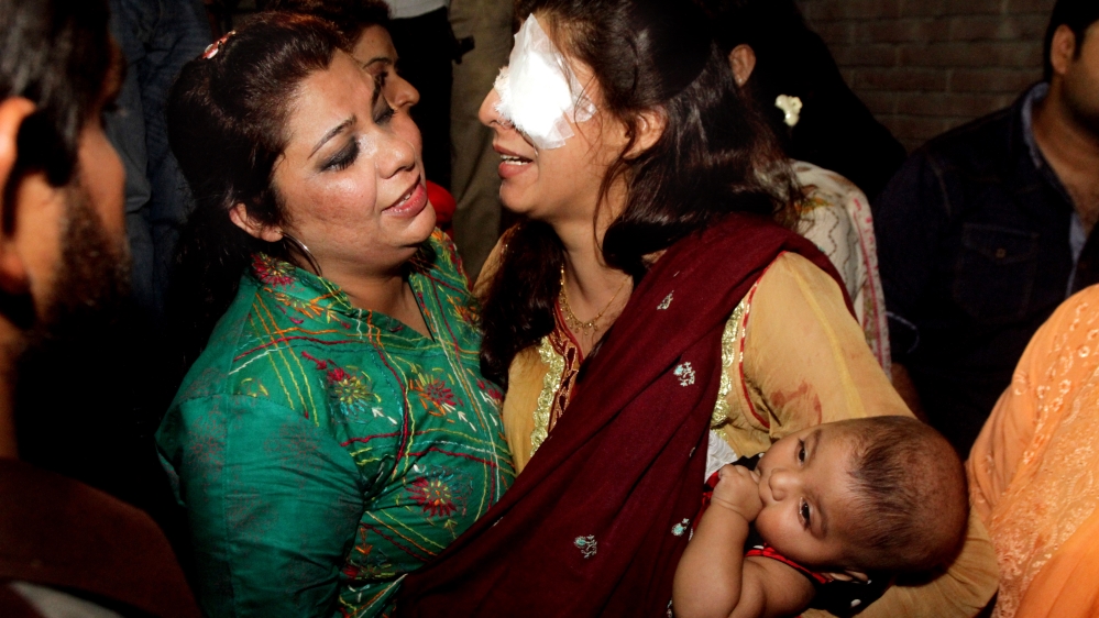 A woman injured in the bomb blast is comforted by a family member at a local hospital in Lahore, Pakistan [AP]