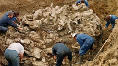 International War Crimes Tribunal investigators clearing away soil and debris