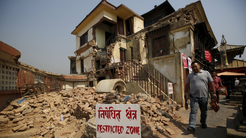 A man walks past the collapsed monastery at the Swoyambhunath Stupa, a UNESCO world heritage site a year after the 2015 earthquakes in Kathmandu, Nepal [REUTERS]