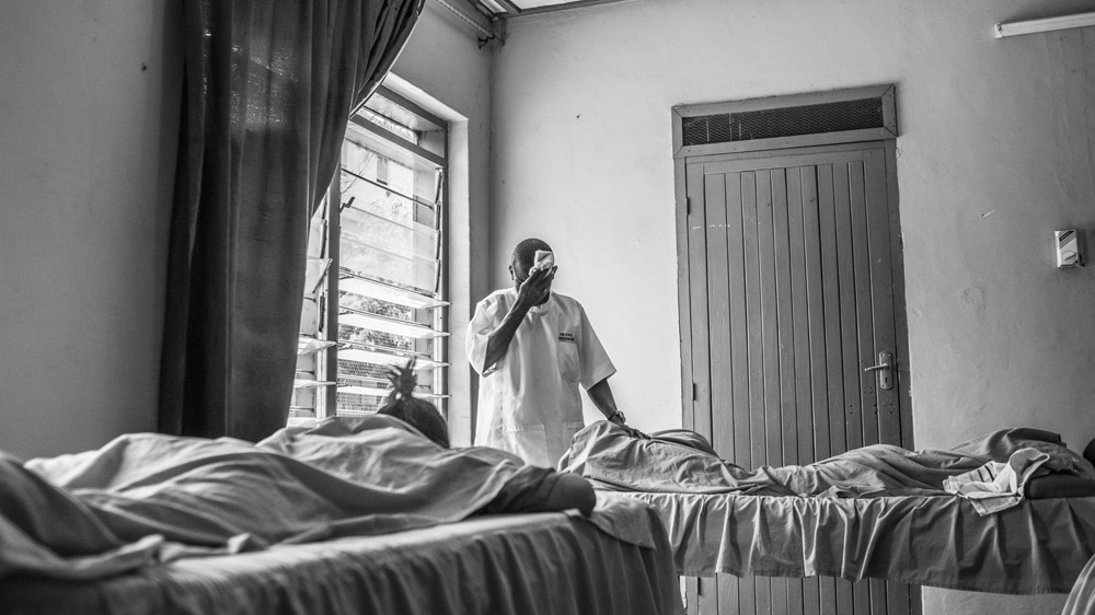 Silvas wipes away his sweat during a massage. Temperatures can top 38C. Massage can be challenging when the power is off and fans stop working [Zach Krahmer/Al Jazeera]