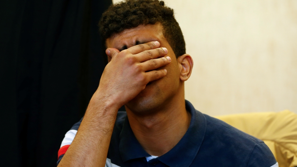 Defendant covers his face at a regional court in Cologne