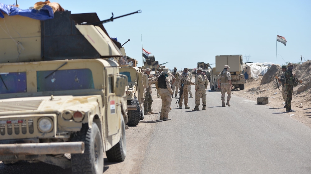 Iraqi soldiers with Shiite fighters gather on the outskirts of Fallujah
