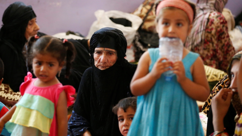 Civilians who fled their homes due to clashes on the outskirts of Falluja, gather in the town of Garma