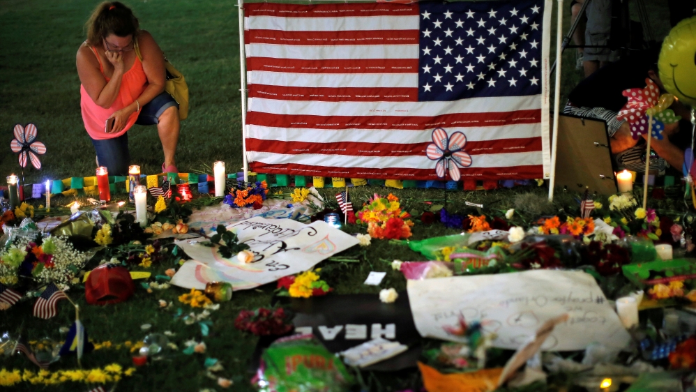 A woman visits a vigil for the victims in the shooting at the Pulse gay nightclub in Orlando