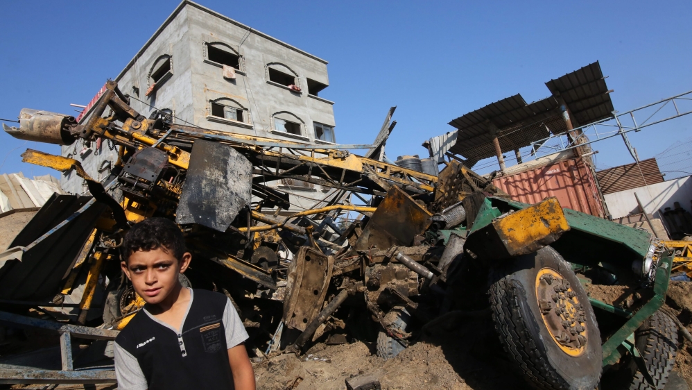 A Palestinian boy looks at the damage following an airstrike by the Isreali army on a workshop in Gaza City [EPA]