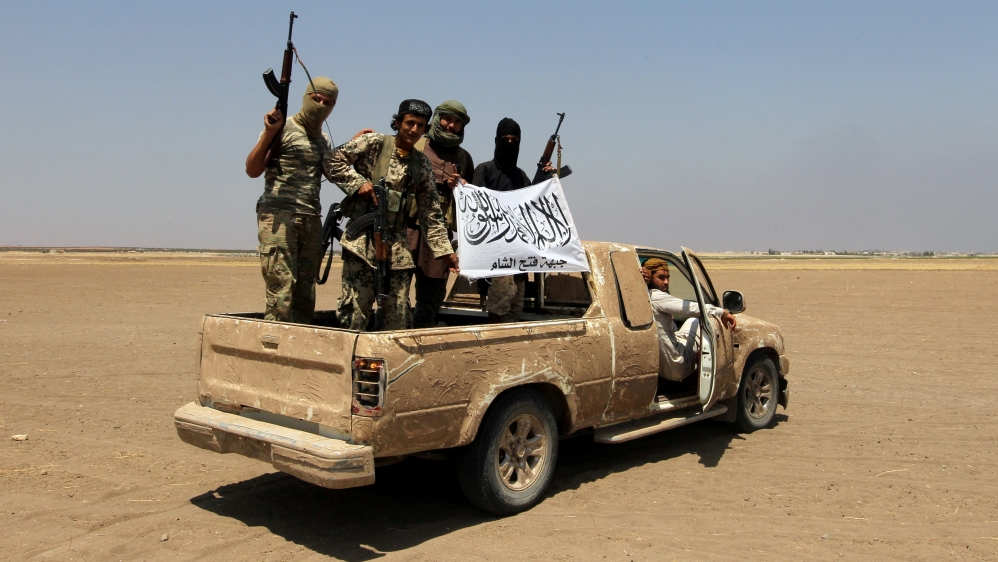Fighters of the Syrian Islamist rebel group Jabhat Fateh al-Sham cheer after a Russian helicopter was shot down in the north of Syria''s rebel-held Idlib province