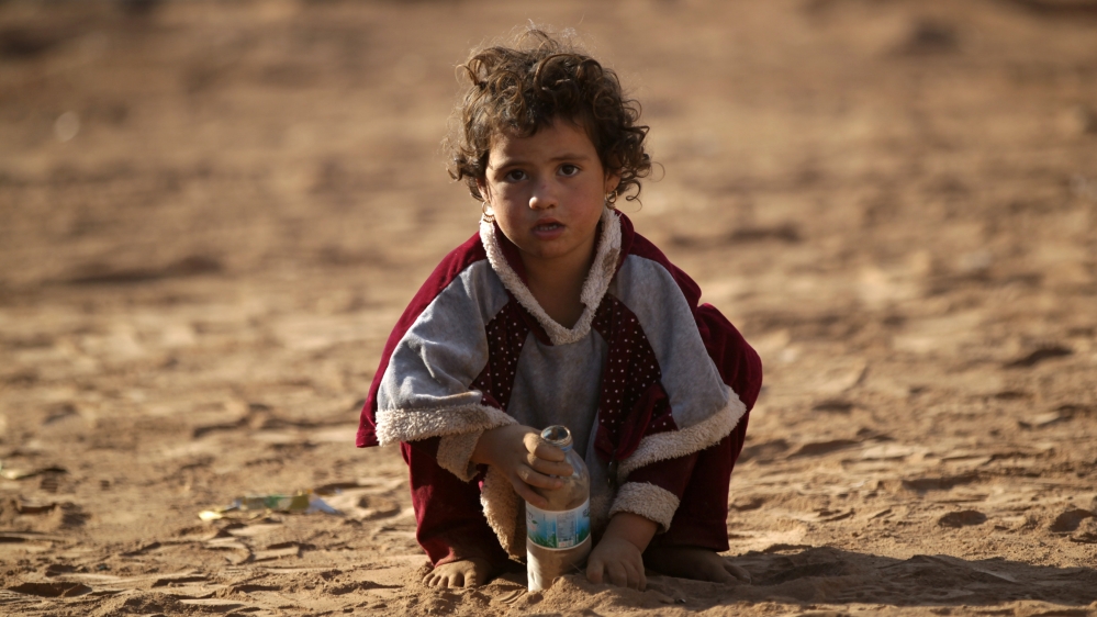 An Iraqi refugee girl that fled violence in Mosul plays with sand upon arrival in al-Kherbeh village, northern Aleppo province, Syria [REUTERS]