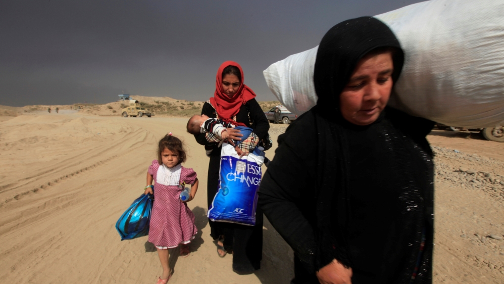 Displaced people who are fleeing from clashes arrive in Qayyarah