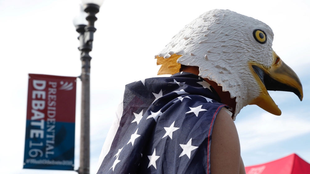 A man wears an eagle mask and is draped in a US flag outside of the event site of the presidential debate between Donald Trump and Hillary Clinton in Missouri, US [REUTERS]