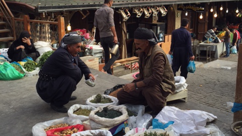 Two Kurdish men talking at the Sulaimania Bazaar in Sulaimania, northern Iraq [photo/Tanya Goudsouzian]