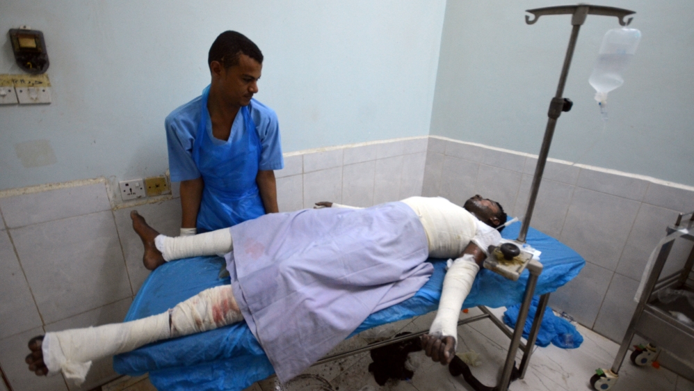 Medic helps a man injured by Saudi-led air strikes on a prison near the Red Sea port city of Houdieda, Yemen