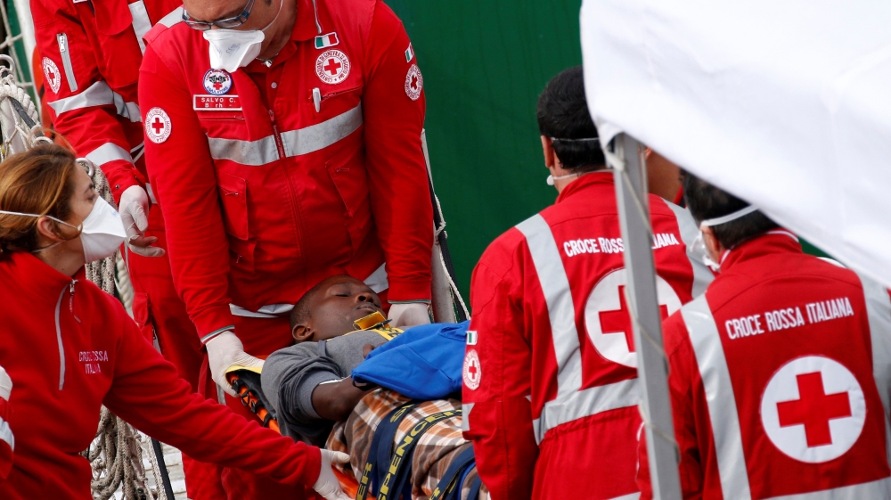 A migrant is carried by members of the Italian Red Cross as he is disembarked from a MSF (Medecins Sans Frontieres) vessel in the Sicilian harbour of Catania