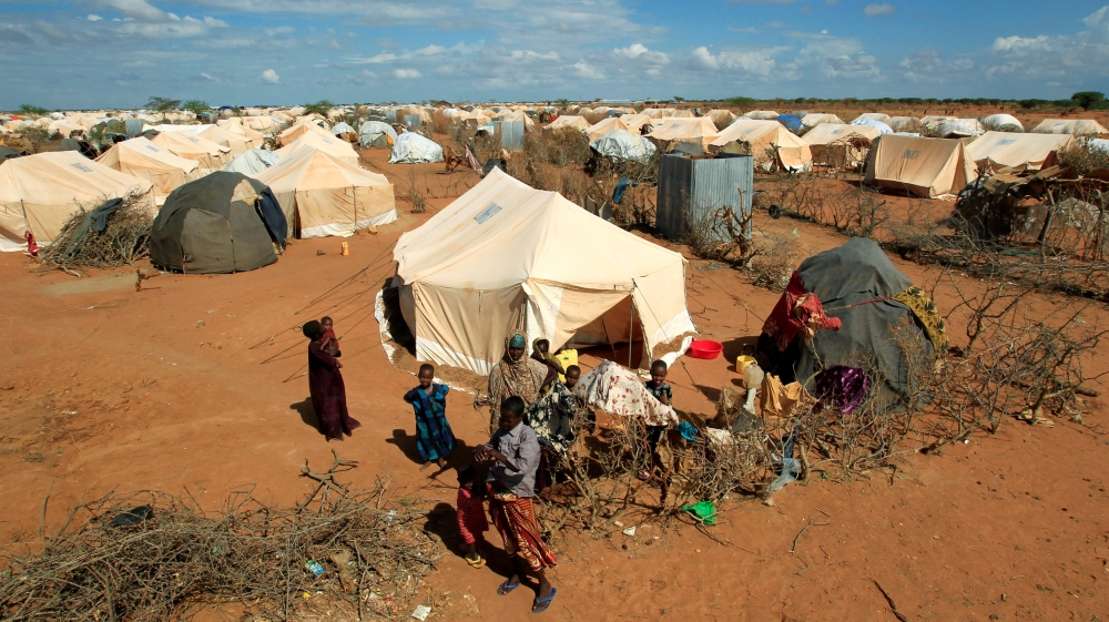 Refugees stand outside their tent at the Ifo Extension refugee camp in Dadaab, near the Kenya-Somalia border in Garissa County, Kenya